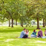 college students sitting together as a group in a park